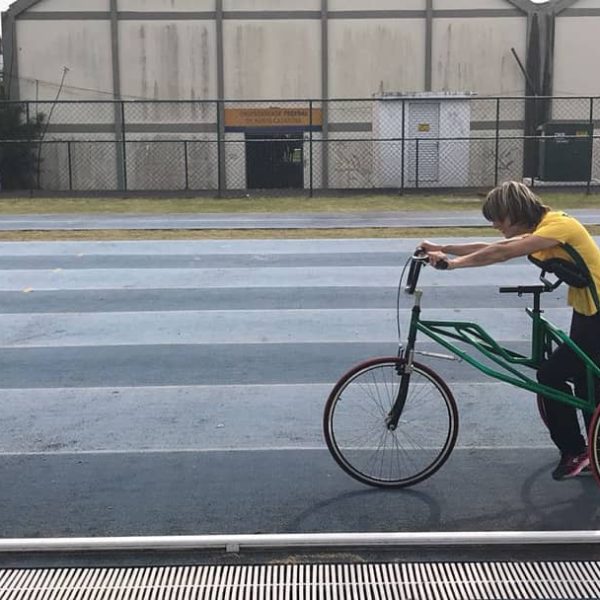 Foto minha e da Kamila na pista da UFSC. A foto é lateral, estou a frente da Kamila que está na petra, orientado ela na atividade.